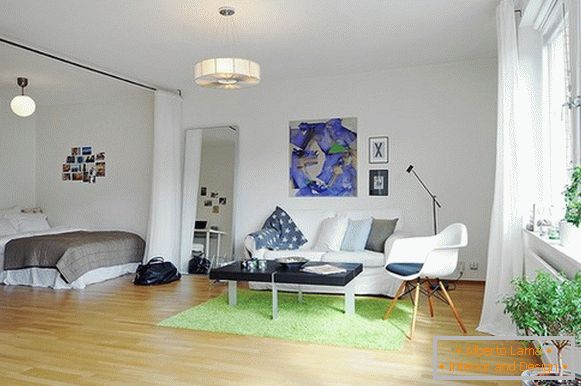 Interiér bytu s oddeleným priestorom s posteľou z bielej opony zo stropu na podlahu