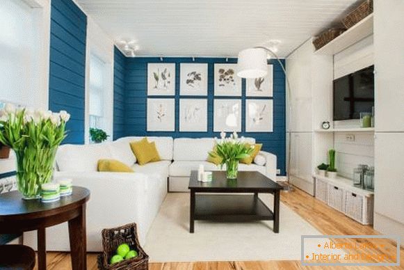 Biela pohovka v interiéri s modrou tapetou a drevenou podlahou