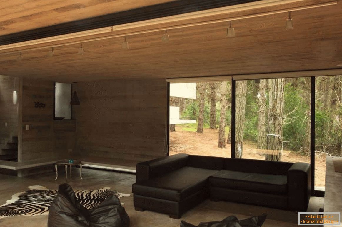 Obývacia izba s dreveným povrchom v drevenom dome s panoramatickým oknom