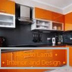 Plochá čierna zástera v oranžovej kuchyni