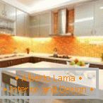 Oranžová zástera a biela kuchyňa