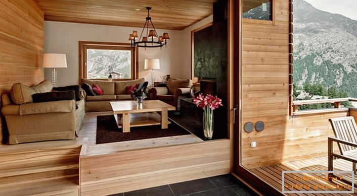 Podkrovná vila s prístupom na verandu je vyzdobená v štýle chaty. Farba ľahkého dreva vyzerá ziskovo v kombinácii s tmavohnedou dlažbou.