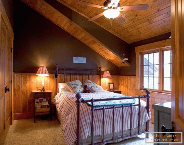 Spálňa pre hostí na podkroví v štýle chaty je priestranná a nie nadbytočná s dekoratívnymi prvkami.