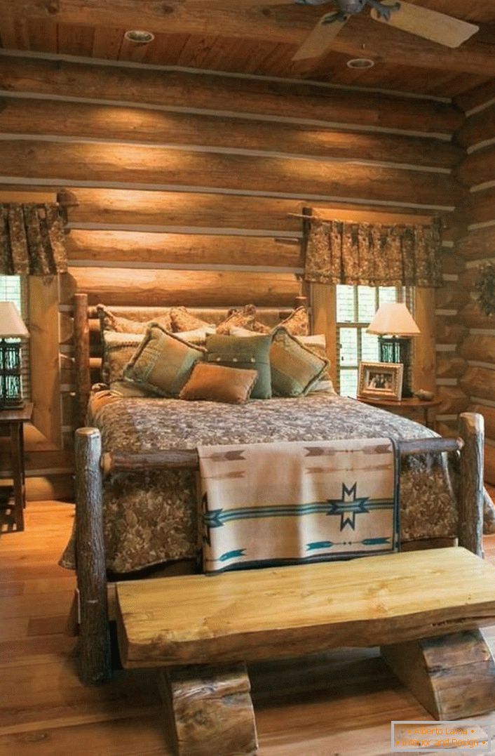 Klasický príklad spálne v rustikálnom štýle. Zaujímavá posteľ drsného, ​​neošetreného zrubového domu. 