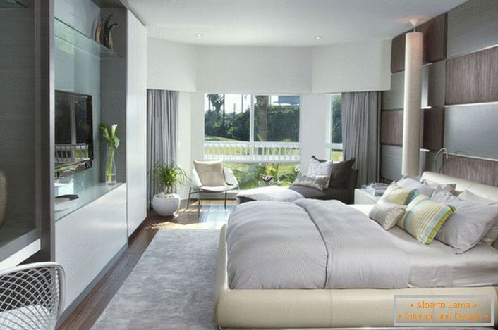 Mäkká, hromadná posteľ v spálni v modernom štýle. Nábytok s lesklým povrchom dobre zapadá do celkového zloženia interiéru.