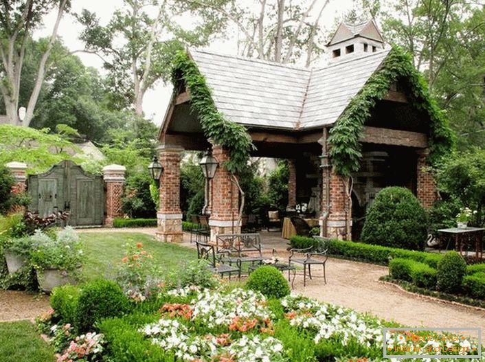 Elegantná jednoduchosť otvoreného altánu v štýle chaty vyzerá ekologicky v luxusnej útulnej záhrade. 