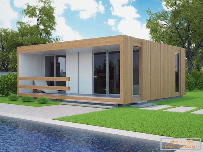 Malý modulový dom s bazénom na dvore. Štýlový dizajn domu, ktorý sa buduje rýchlo, vyzerá ekologicky na pozadí krátkeho orezaného trávnika.