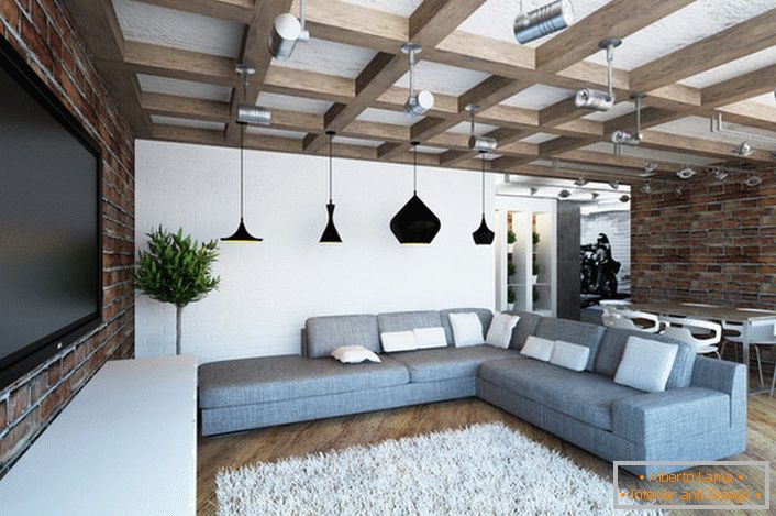 Útulná svetlá obývacia izba v podkroví. Harmonická kombinácia murovaných murovaných stien a masívnych trámov. 
