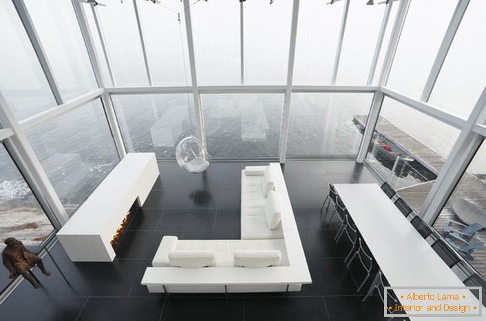 Laconický dizajn obývacej izby v minimalistickom štýle. Zaujímavým kusom nábytku je stolička zavesená z vysokého stropu.