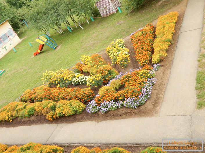 Modulárna kvetinová záhrada vo forme žiarivého slnka harmonicky vyzerá na ihrisku.