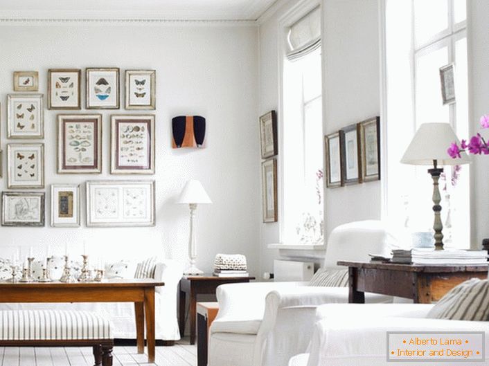 Útulná obývacia izba v škandinávskom štýle je vyrobená v bielom. Je zaujímavé zdobiť stenu rámmi rôznych veľkostí.