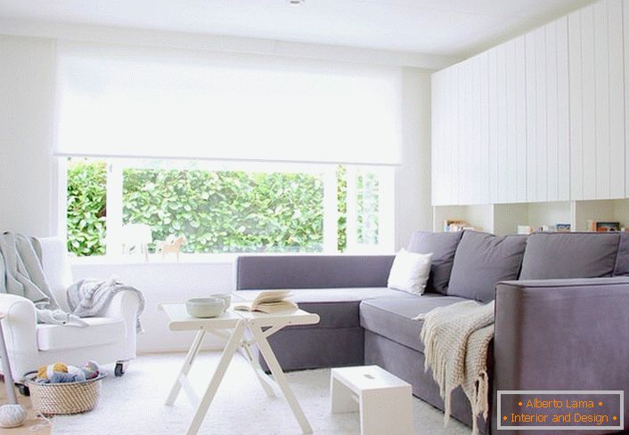 Kombinácia bielej a šedej farby vždy vyzerá ziskovo, najmä ak je to škandinávsky štýl. Obývacia izba s mäkkým nábytkom je priestranná a svetlá.