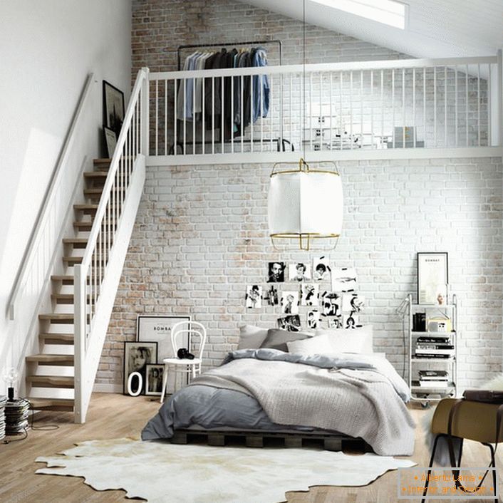 Spálňa v škandinávskom štýle je funkčne rozdelená na dve zóny. Drevené schodisko vedie do druhého poschodia, kde je na posteli malá šatňa.