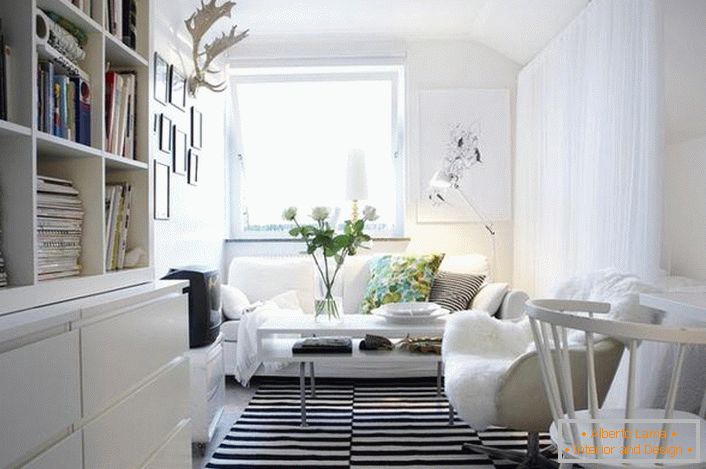 Klasická kombinácia čiernej a bielej farby vyzerá ako výnosná v interiéri v škandinávskom štýle. Biely nábytok vytvára svetlo a útulnosť v obývacej izbe.