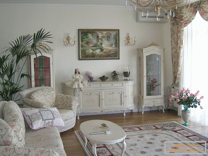 Priestranná obývacia izba je vyzdobená v romantickom štýle vo svetlých farbách.