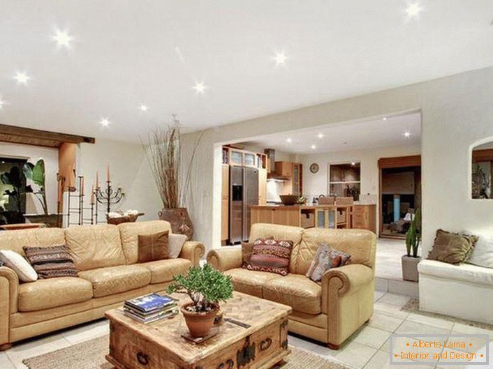 Luxusný, štýlový interiér obývacej izby v stredomorskom štýle. Mäkký, svetlo béžový nábytok, riadne vybrané osvetlenie, dlažba - svedčí o stredomorskom štýle.
