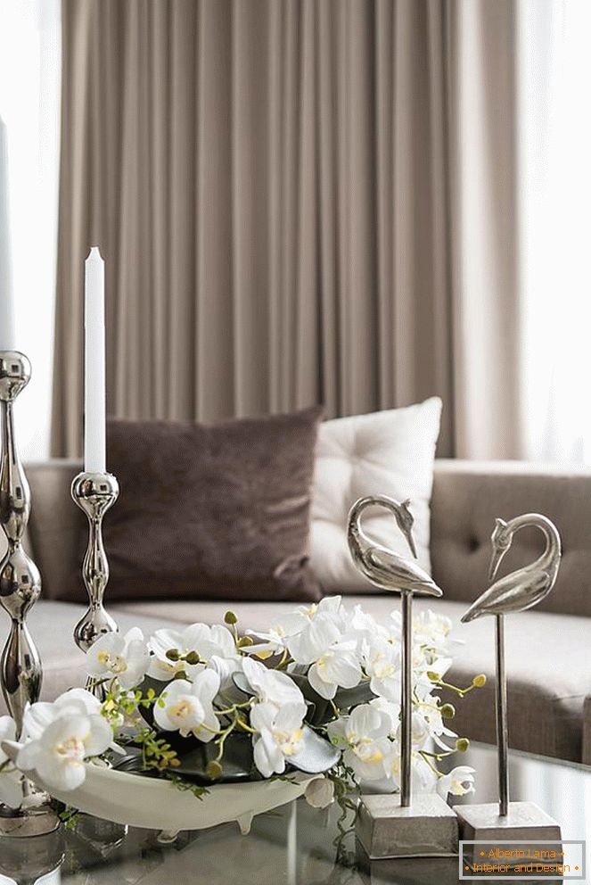 Zloženie orchideí, sviečok a iných dekoratívnych prvkov na stole v obývacej izbe