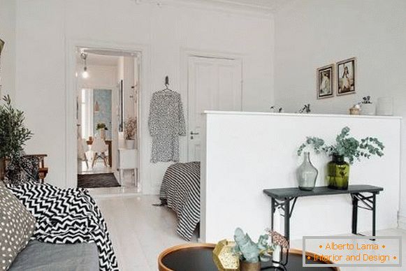 Rozdelenie medzi obývacou izbou a spálňou v apartmáne v škandinávskom štýle