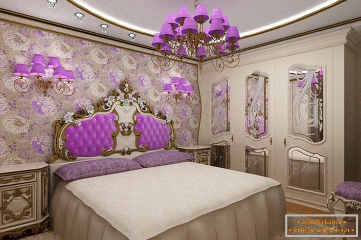 Elegantná baroková spálňa so zaujímavým dôrazom na osvetlenie. Lustrové a nočné lampy s rovnakými fialovými odtieňmi harmonicky kombinované s čalúnením operadla na hlave lôžka.