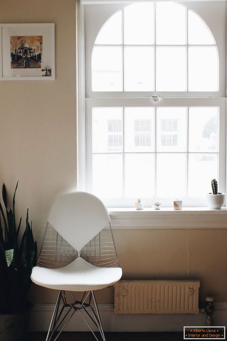 Biela stolička pri veľkom okne