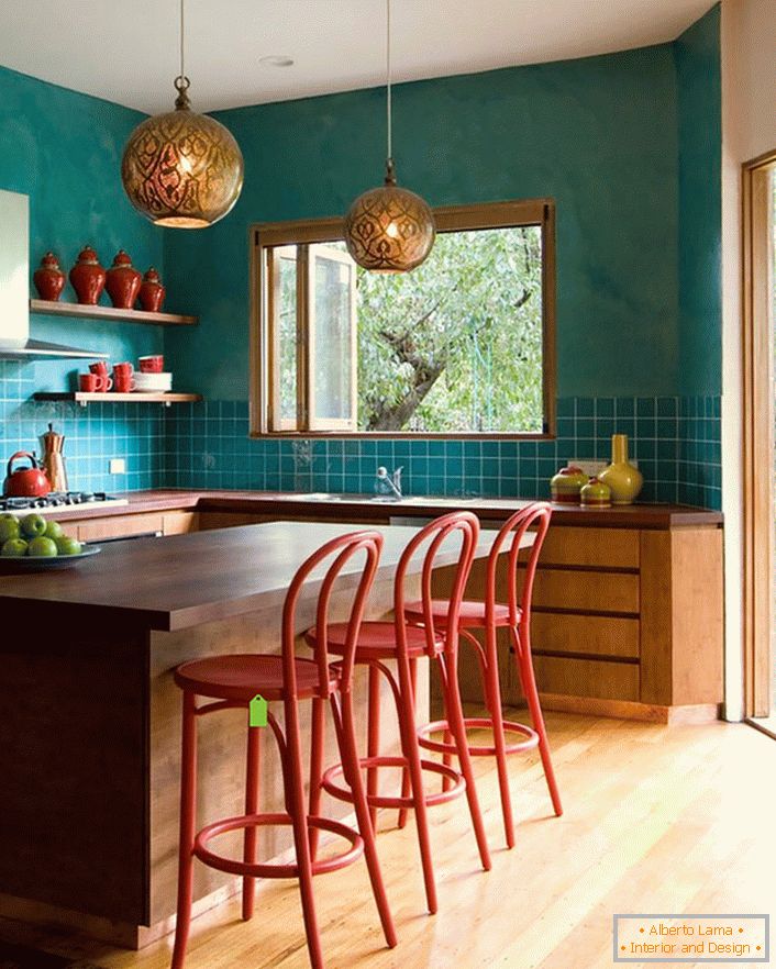 Tyrkysová dekorácia stien v kuchyni robí izbu priestrannejšou. Laconický, skromný nábytok bez problémov zapadá do celkového interiéru v štýle eklektiky.