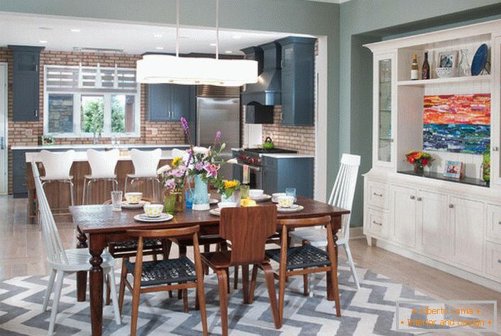 Kuchyňa s veľkým eklektickým štýlom je rozdelená na pracovnú a jedáleň. Nábytok bielej farby je kombinovaný s prvkami interiéru tmavo-hnedej farby.