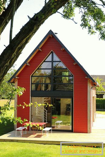 Interiér malého dreveného domu s veľkými oknami