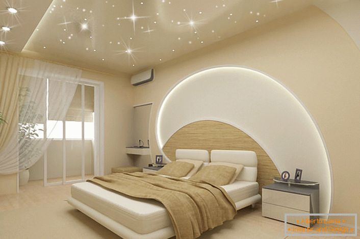 Pozornosť priťahuje dekoráciu stien a stropu v spálni v modernom štýle. LED pásy prechádzajú stropom a stenou nad posteľou, strešné stropy napodobňujú magickú hviezdnu oblohu.