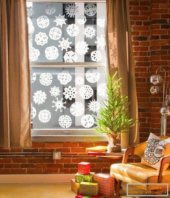 Rezanie a lepenie snehových vločiek na oknách na Nový rok