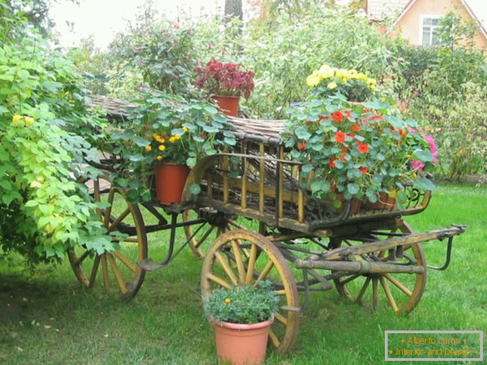 Originálne kvetinové záhony v štýle krajiny môžu byť vyrobené zo starého vozíka alebo zbytočného bicykla.