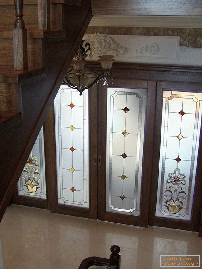 Dvere so sklenenými vložkami sú zdobené matným farebným sklom s nekomplikovaným vzorom. Nie prestížny, zdržanlivý dizajn dverí bude organicky zapadajúci do klasického interiéru sály. 