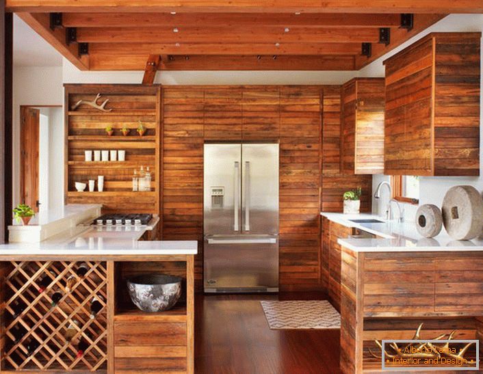 Moderná kuchyňa v štýle chaty je pozoruhodná svojou lakonickou dekoráciou. Sada dreva bez prídavného nábytku vyzerá štýlovo a efektívne.