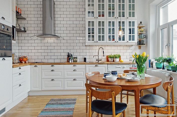 Interiér kuchyne je vyrobený v škandinávskom štýle, ktorý je vyjadrený v bielej, pokojnej konštrukcii. 