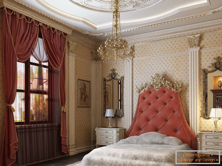 V strede dizajnovej kompozície je posteľ s vysokou čelo, čalúnená mäkkou tkaninou farby čajovej ruže. 