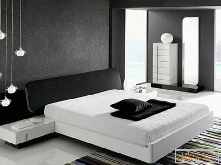Stenu v hlave postele, zdobený šedou matnou vložkou v súlade so štýlom hi-tech je v súlade s lesklou bielou podlahou.