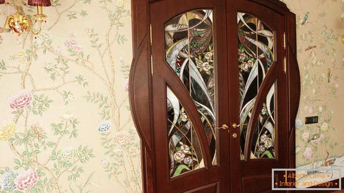 Jednou z požiadaviek modernistického štýlu je prirodzenosť použitých materiálov. Interiérové ​​dvere z prírodného dreva Wenge sú zdobené atraktívnym farebným sklom. 