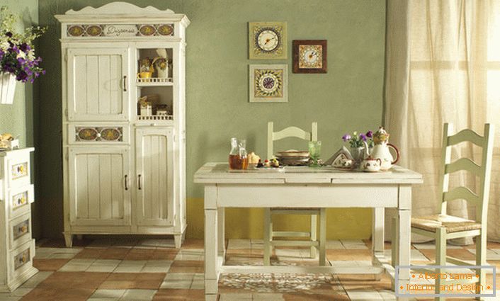 Útulná kuchyňa v štýle krajiny je prevedená v bielom a jemnom olivovom svetle. Dokonalá kombinácia farieb pre rustikálny štýl.