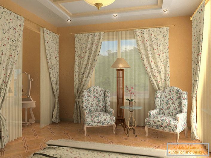 Spálňa v anglickom štýle s nezvyčajným zákrutom. Pre čalúnenie nábytku, záclon a posteľných prikrývok bola vybraná jedna látka s nepružným kvetinovým vzorom.