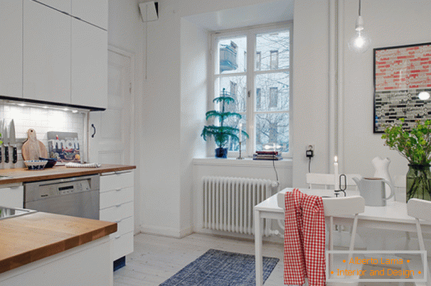Kuchyňa s jedálenským kútom malého bytu v škandinávskom štýle