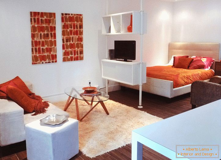 Interiér bieleho štúdiového apartmánu s oranžovými akcentmi